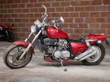 a red motorcycle parked in a garage next to a brick wall