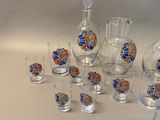 many glasses and a decanter sitting on a table