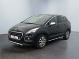 La voiture noire est garée dans une pièce aux murs blancs.
