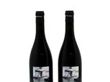 two bottles of wine sitting next to each other on a white surface
