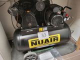 un compresseur noir posé sur un sol carrelé