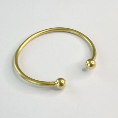 un gros plan d'un bracelet en or orné de deux boules
