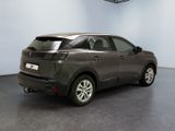 the rear end of a grey car in a room with a ceiling fan