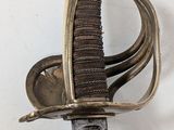 a close up of a sword on a white surface