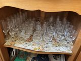 many wine glasses sitting on a shelf in a cabinet