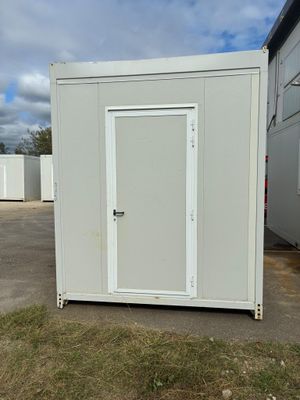 une photo représentant des toilettes portables blanches dans un parking