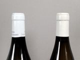 two bottles of wine sitting on a table next to each other