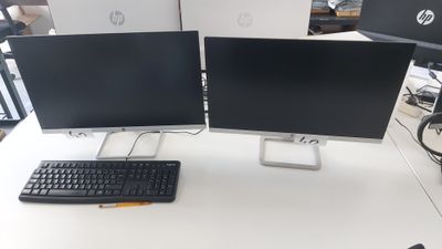deux écrans d'ordinateur et un clavier sur un bureau