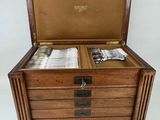 an old wooden box with a bunch of silvers inside of it