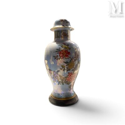 un vase muni d'un couvercle posé sur une surface blanche