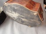 a suitcase that is sitting on a bed next to a pair of shoes