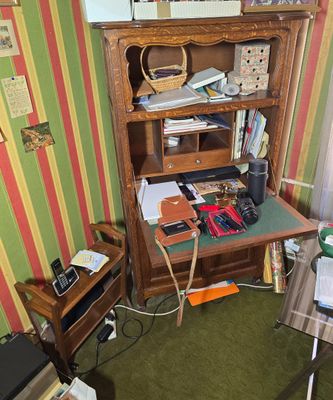 une photo d'une pièce en désordre avec un bureau et une chaise