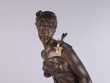 bronze statue of a woman with a bird on her shoulder