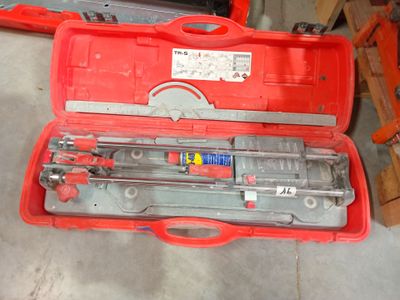 une caisse à outils rouge avec des outils sur le sol