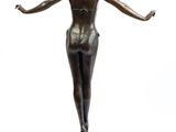 bronze statue of a woman standing on a pedestal with her arms outstretched