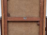 an old wooden easel with a painting on it and a box of paint