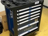un chariot à outils noir sur lequel se trouvent tout un tas d'outils