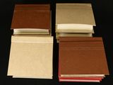 four books are lined up on top of each other on a black surface
