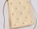 beige leather handbag with silver stars on the side