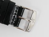 black leather watch strap with silver buckle on a white surface