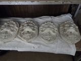 four stone heads are sitting on top of a sheet of paper