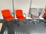 three chairs and a table in a room with white walls