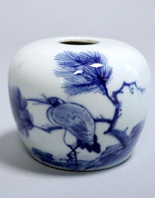 a blue and white vase with a bird on it