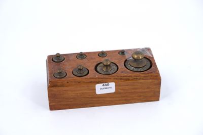 a small wooden box with buttons on it on a white surface