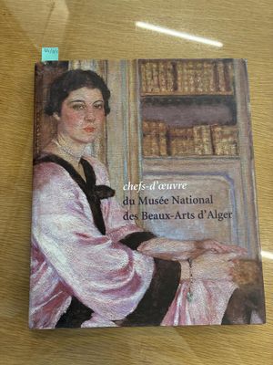 a book on a table with a picture of a woman in a pink dress