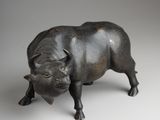 bronze figurine of a bull on a white background