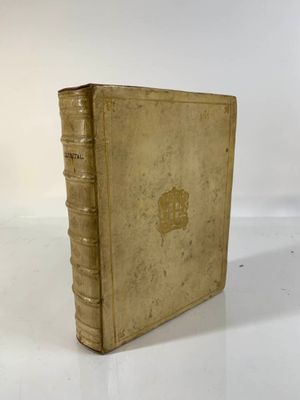 an old book sitting on top of a white table next to a white wall