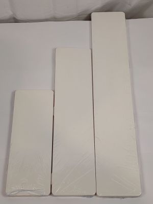 quatre morceaux de plastique blanc sont posés sur une surface blanche