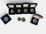 six silver coins and a silver coin are in a case