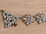 three pieces of jewelry sitting on top of a wooden table