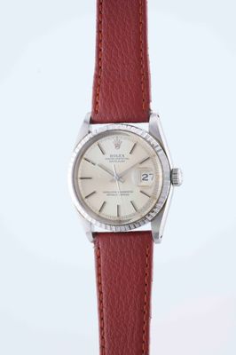 a close up of a wrist watch with a red leather strap