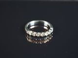 gros plan d'une bague en argent sur une surface noire