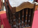 a wooden chair with a marble top on a red table