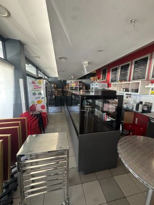 tables and chairs in a restaurant with a menu on the wall