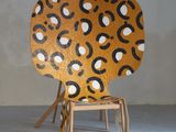 une chaise dont l'assise en bois est ornée d'un motif
