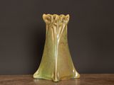 a green vase sitting on a table with a black background