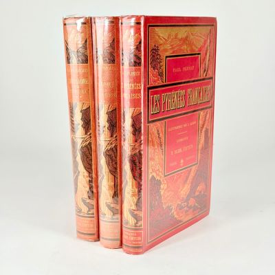 trois livres sont empilés sur une surface blanche