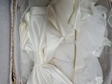 a wedding dress and veil in a basket on a table
