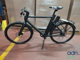 a black bike that is parked in a warehouse