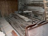 un tas de bois posé dans une pièce, avec une échelle à côté