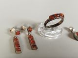 three pieces of jewelry sitting on top of a table next to each other