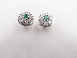 a pair of emerald and diamond earrings on a white surface