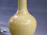 a yellow vase that is sitting on a table