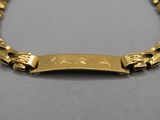 un gros plan d'un bracelet en or orné d'une plaque