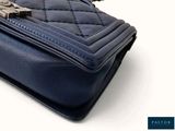 the blue purse has a chain hanging from it ' s strap
