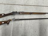 trois armes sont posées par terre près d'un mur